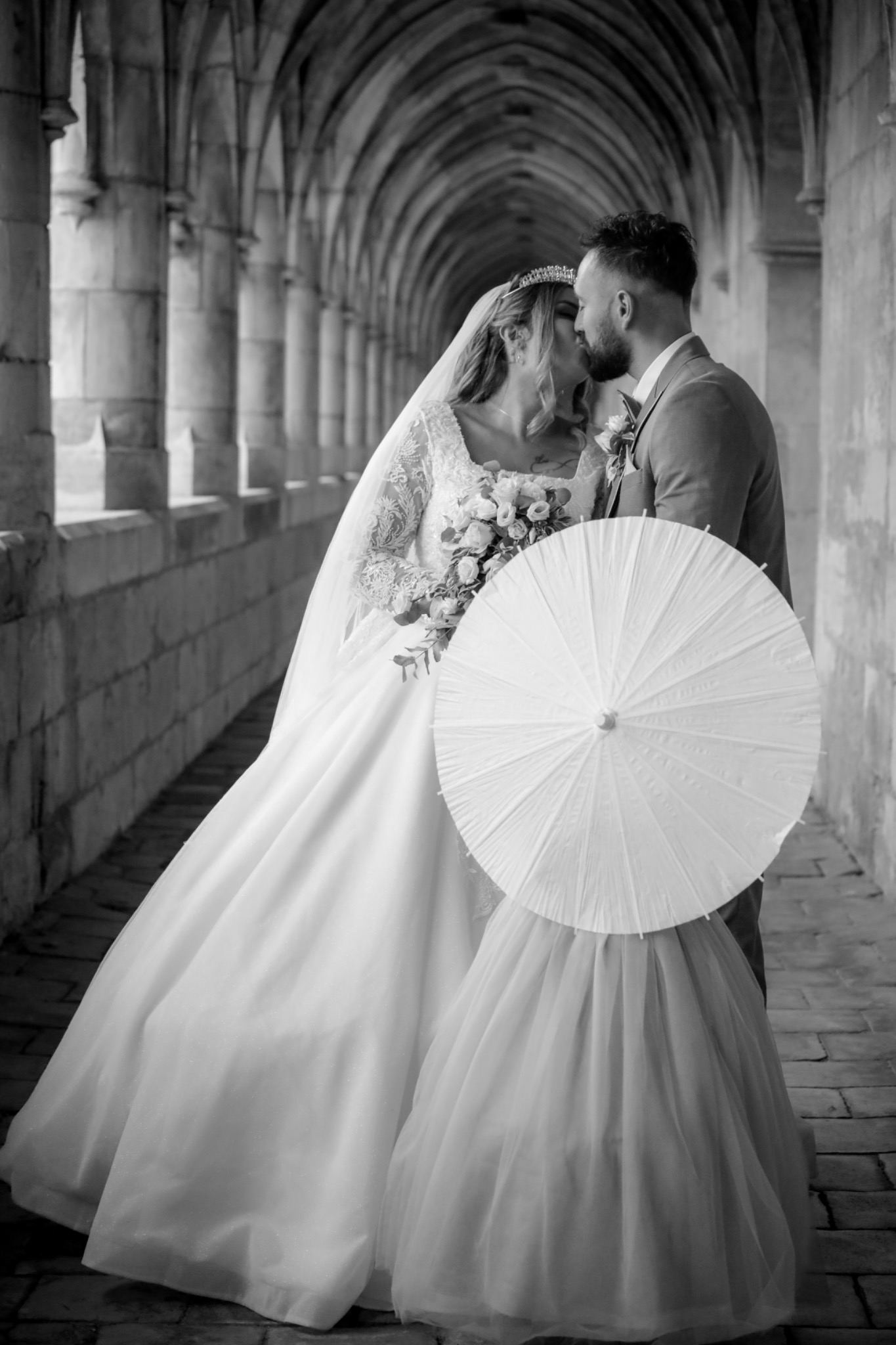 Black and white portrait of newlyweds beneath the arches