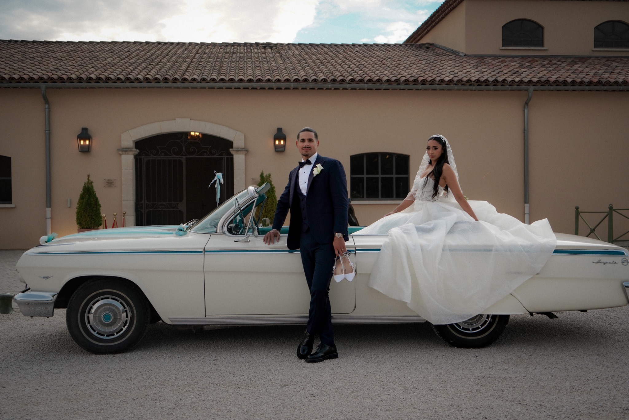 Newlyweds beside a classic car