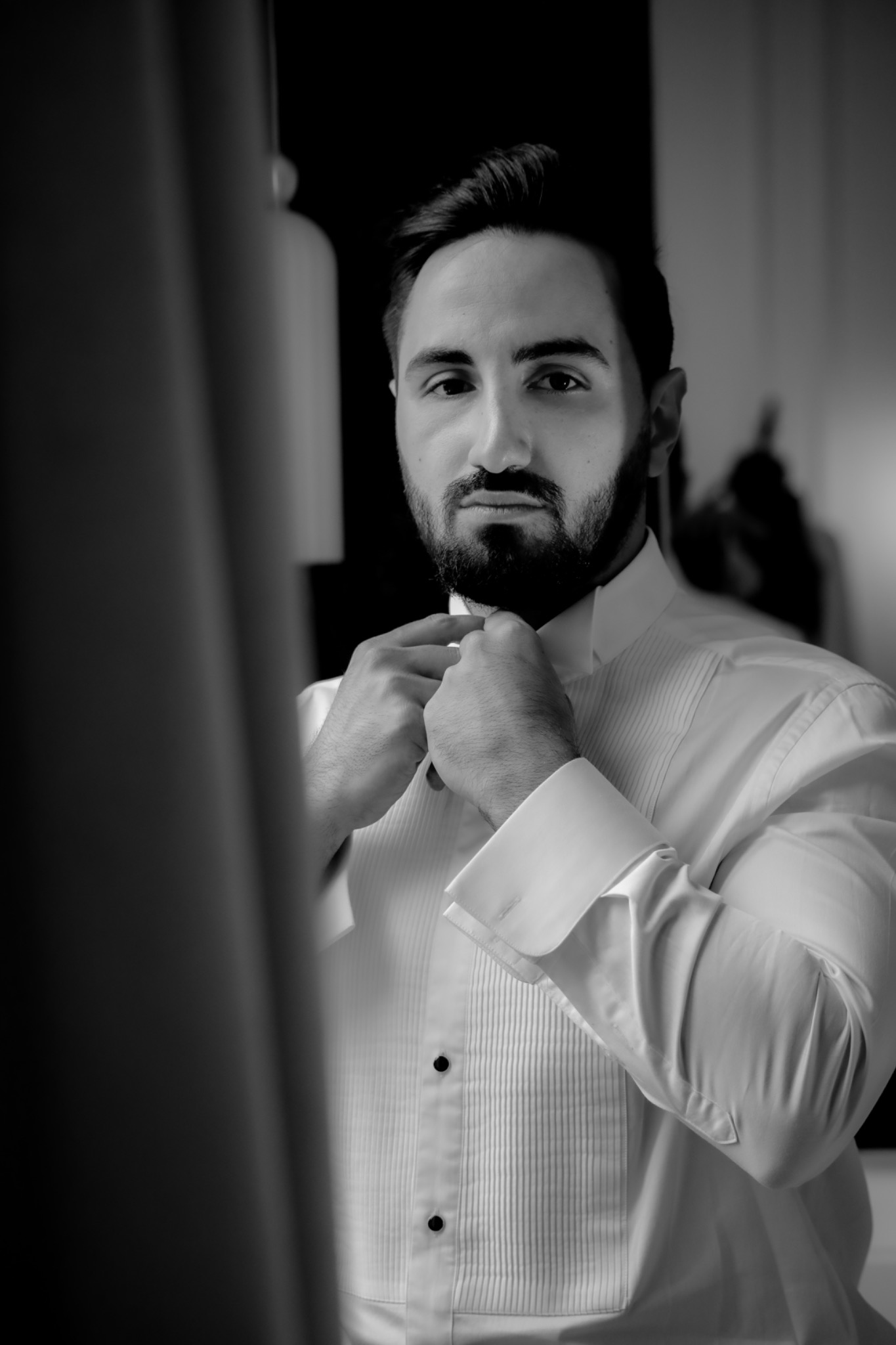 Black and white portrait of the groom getting ready