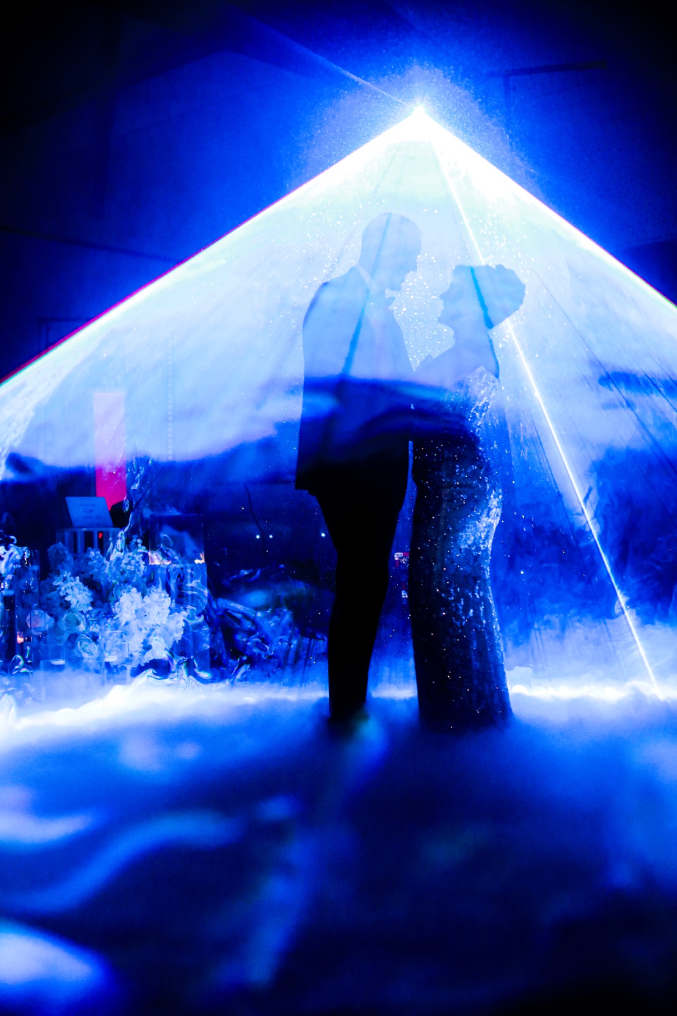 Newlyweds silhouetted against blue lighting